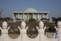  꽃봉우리 철책장식 뒤의 국회의사당