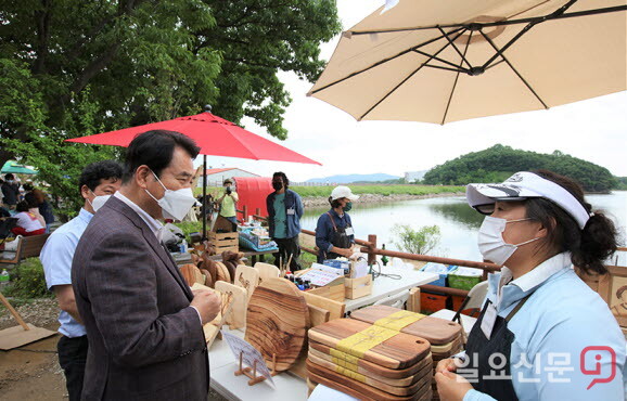 백군기 용인시장이 처인구 원삼면 용담호수에서 열린 '제2회 용담호수뚝마켓'에서 관계자들과 이야기를 나누고 있다./사진=용인시