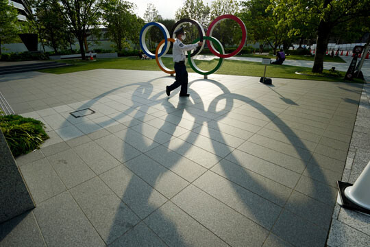 ‘폭탄 돌리기 게임’이 따로 없다. IOC, 일본 정부, 도쿄도 등 주최 측은 예정대로 대회를 강행하겠다는 입장이지만 서로 책임을 떠넘기기 시작했다. 올림픽 후원사들도 도망갈 자세가 역력해 보인다. 도쿄 올림픽 경기장 앞에서 마스크를 쓴 채 걷고 있는 경비원의 모습. 사진=AP/연합뉴스