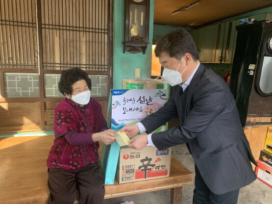 노영동 경남지역보증센터장이 관내 어려운 독거노인에게 상품권을 전달하는 모습. 사진=경남농협
