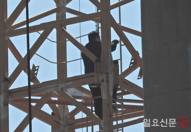 경동건설 타워크레인 조종사는 안전모도 착용하지 않은 채 고공 작업을 위해 사다리를 오르고 있다. 사진=정민규 기자