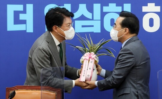 박홍근 더불어민주당 신임 원내대표(오른쪽)가 3월 25일 서울 여의도 국회에서 장제원 대통령 당선인 비서실장과 만나 윤석열 당선인의 축하 난과 메시지를 전달 받고 있다. 사진=이종현 기자