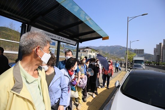 정부가 일상회복을 예고한 가운데 봄과 맞물려 활기가 더해지고 있다. 정류장에서 버스를 기다리는 시민들. 사진=남경원 기자