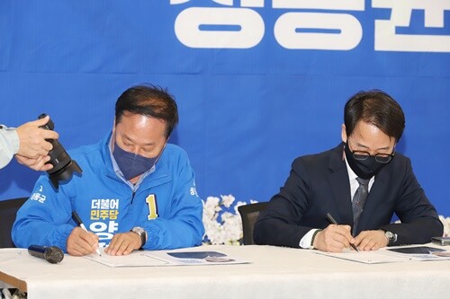 정동균 후보와 김동연 더불어민주당 경기도지사 후보 선대위원장인 이원욱 국회의원이 협약서에 서명하고 있다. 사진=김현술 기자