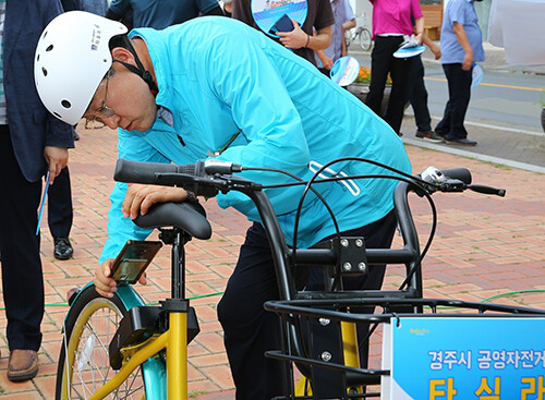 지난 7일 경주 봉황대 앞 광장에서 열린 공영자전거 개통식에 참석한 주낙영 시장이 스마트폰 앱으로 타실라를 대여하고 있다. 사진=경주시 제공