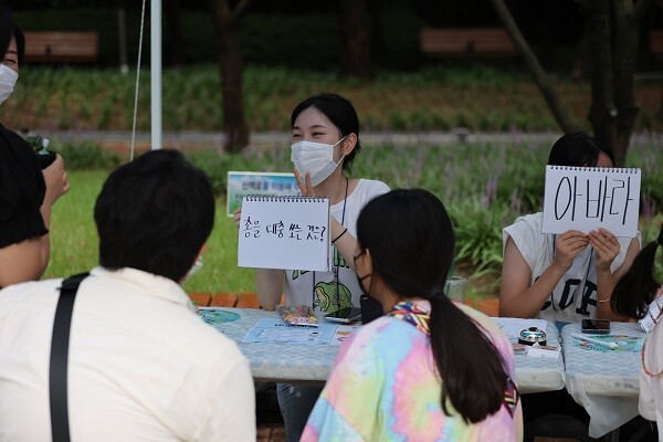 '총을 대충 쏘는 것은?' 신조어퀴즈 부스에서 학생이 학부모에게 퀴즈를 내고 있다. 어려워하는 시민에게 힌트를 주는 장면. 사진=남경원 기자