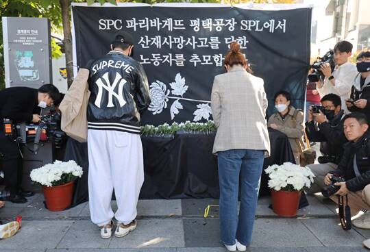 20일 오후 서울 양재동 SPC 본사 앞에서 열린 '평택 SPC 계열사 SPL 평택공장 산재사망 희생자 서울 추모' 행사에서 참가자들이 헌화하고 있다. 사진=박정훈 기자