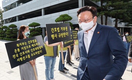 조규홍 보건복지부 장관이 5월 16일 서울 고려대학교 안암병원에서 현장 간담회에 참석하는 가운데, 고려대 안암병원 간호사와 전국보건의료산업노동조합 조합원들이 윤석열 대통령의 간호법 제정안 거부권 행사를 규탄하며 팻말을 들고 있다. 사진=연합뉴스