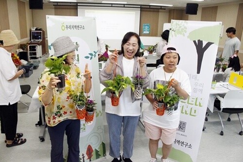 우리지역연구소의 자원순환 에코스쿨 교육프로그램 참여자들이 예쁜 화분 걸이에 담아 완성한 ‘손바닥 정원’을 들고 즐거워하고 있다. 사진=김현술 기자.