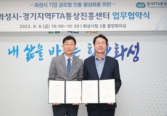 정명근 화성시장과 강경식 경기FTA통상진흥센터장이 8일 업무협약을 체결한 뒤 기념촬영하고 있다. 사진=화성시 제공