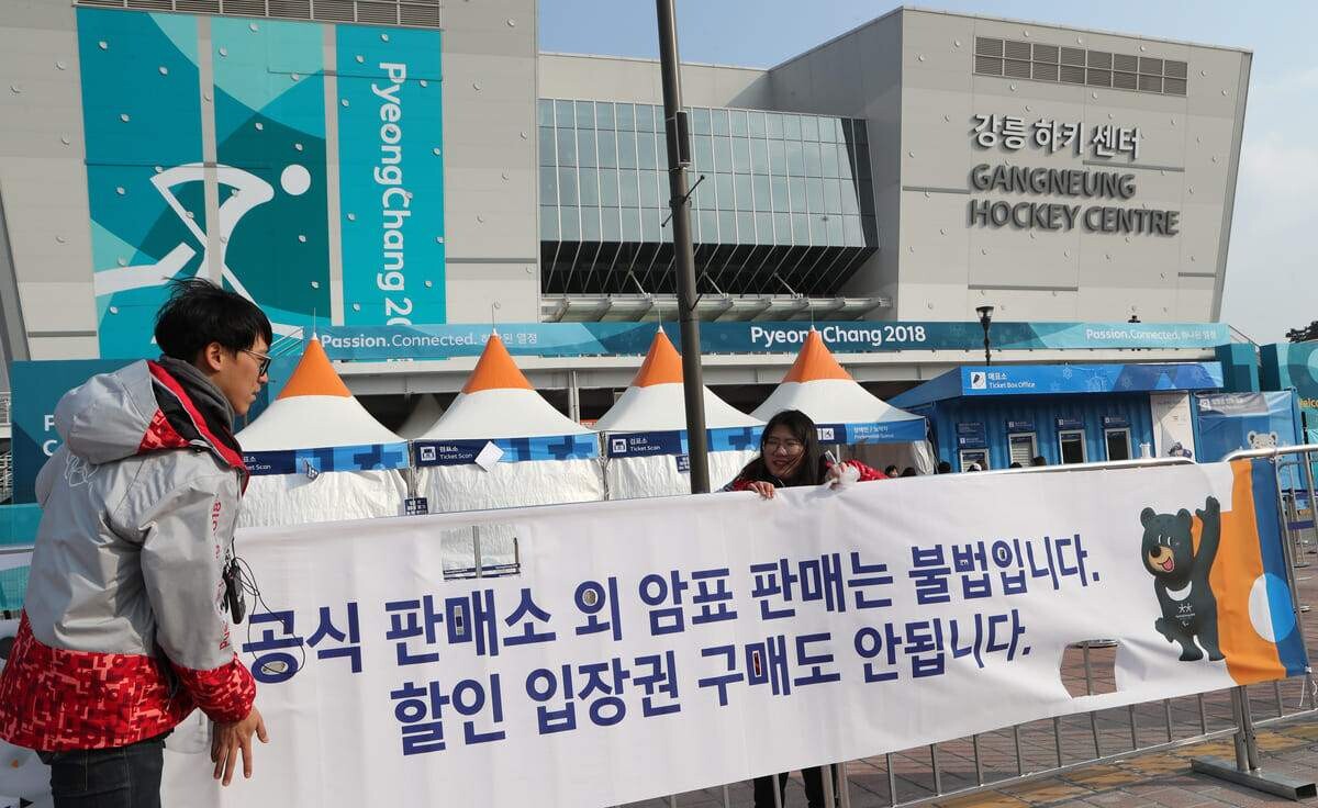 지난 2018년 강릉올림픽파크에서 자원봉사자들이 강릉하키센터 앞에 ‘암표는 불법’이라는 현수막을 부착하고 있다. 사진=연합뉴스