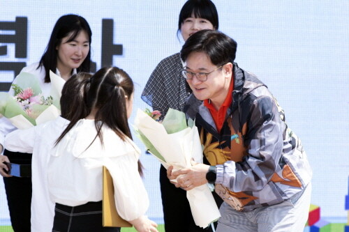 어린이날을 맞아 김병수 김포시장이 아이들의 눈높이에 맞춰 축하 꽃다발을 전달하고 있다. 사진=김포시 제공