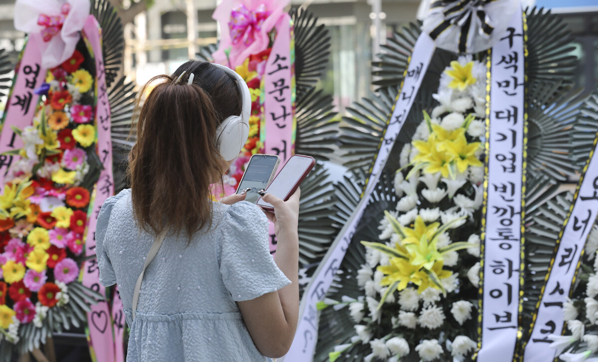 해외 아미가 근조 화환 앞에서 SNS를 하는 모습.