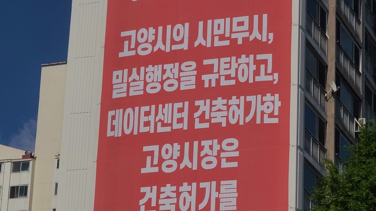 지난 8일 고양시 일산서구 덕이동 데이터센터 건설 추진지 인근의 아파트 외벽에 센터 건축 허가를 반대하는 대형 현수막이 걸려 있다. 사진=이강훈 기자