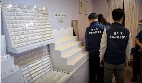 매장 내 짝퉁 액세서리를 진열하고 판매 중인 현장을 단속하는 특사경. 사진=경기도 특사경 제공