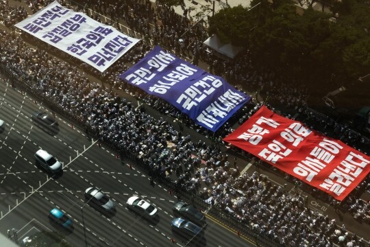 18일 서울 영등포구 여의도 환승센터 주변에서 열린 대한의사협회 전국 의사 총궐기대회에서 참석자들이 대형 현수막 퍼포먼스를 펼치며 정부의 '의대 증원' 철회를 촉구하고 있다. 사진=최준필 기자