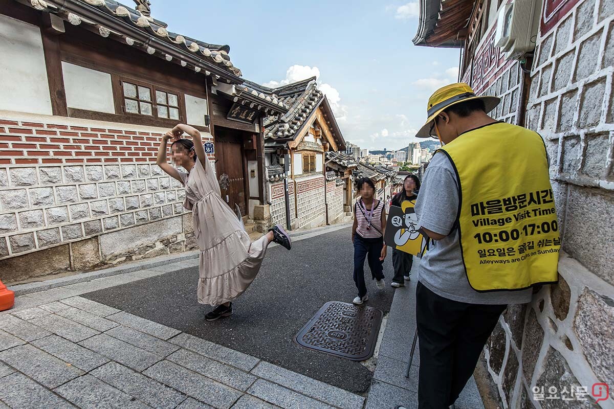 15일 서울 종로구 북촌한옥마을에서 안내원들이 소음유발방지를 당부하는 조끼를 입고 있다.
