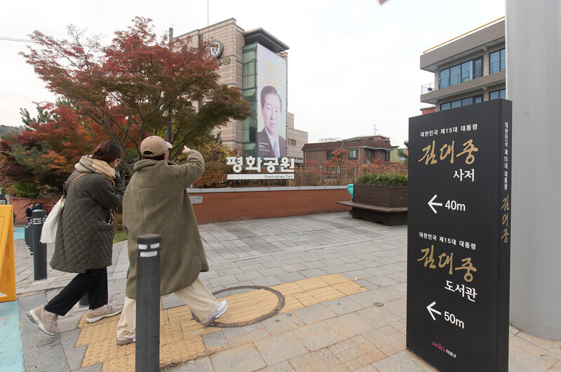 20일 오전 '김대중길'을 지나던 행인들이 김대중 대통령 사저와 도서관을 가리키며 대화를 나누고 있다.