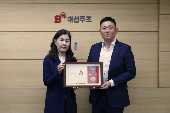 대선주조 조우현 대표(오른쪽)가 대한적십자사 부산지사 박선영 사무처장에게 회원유공장을 전달받았다. 사진=대선주조 제공