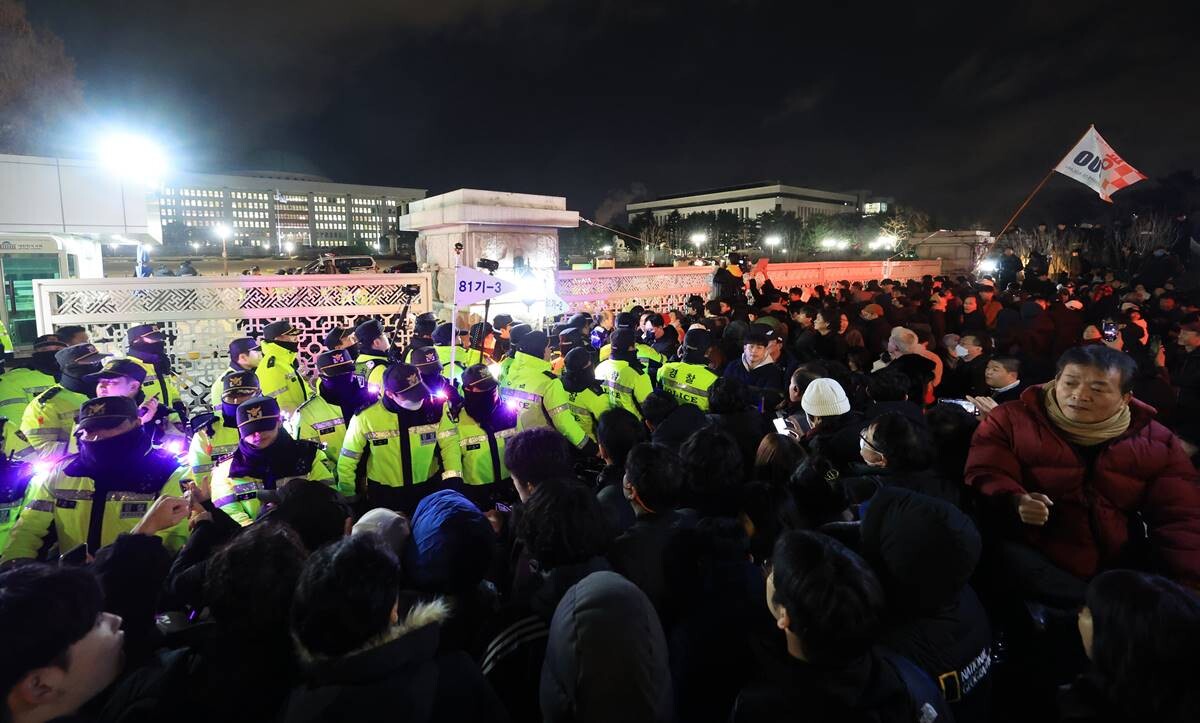 지난해 12월 3일 비상계엄 선포 후 국회 앞에서 시민들이 국회 출입을 통제하는 경찰과 대치하고 있다. 사진=연합뉴스