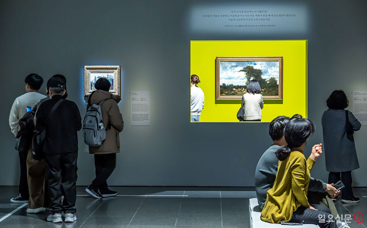 노란색 프레임 너머로 보이는 풍경화와 카미유 피사로의 '겨울 아침의 몽마르트르 대로'(왼쪽)가 관람객들의 시선을 사로잡고 있다.