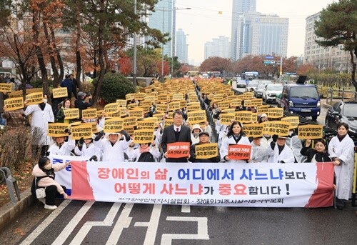 27일 서울 여의도 국회의사당 앞에서 열린 ‘탈시설 지원법’ 폐지 촉구 집회. 비바람 속에서도 1,000여 명의 참가자들이 손팻말을 들고 목소리를 높였다. 사진=김현술 기자