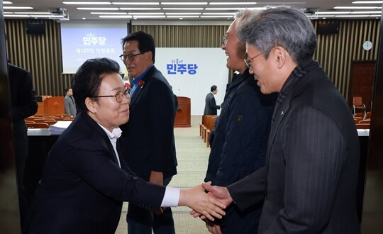 더불어민주당 최고위원 보궐선거 출마를 선언한 문정복 의원(왼쪽)이 12월 16일 국회에서 열린 의원총회에 참석하는 의원들과 인사를 나누고 있다. 사진=연합뉴스