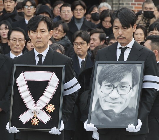 1월 9일 오전 서울 중구 명동성당에서 열린 배우 안성기의 장례 미사가 끝난 뒤 고인의 영정과 금관문화훈장을 든 배우 정우성, 이정재가 영결식장으로 향하고 있다. 사진=박정훈 기자