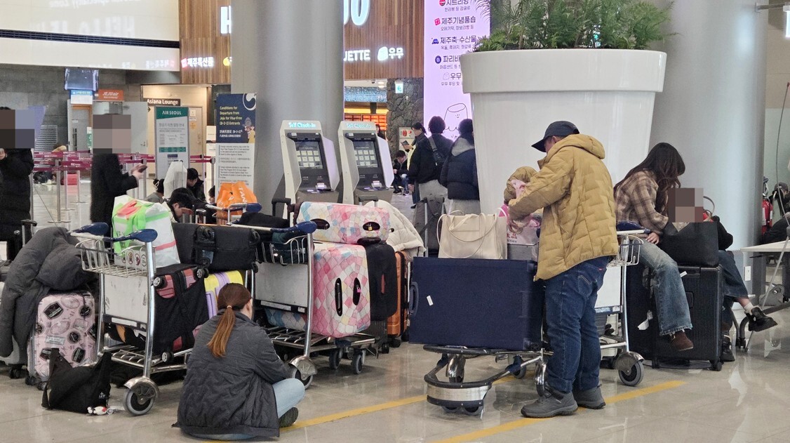 8일 오전 제주국제공항이 폭설로 운영이 중단된 가운데 제주공항 3층 출발장에서 이용객들이 운항 재개를 기다리고 있다. 사진=연합뉴스