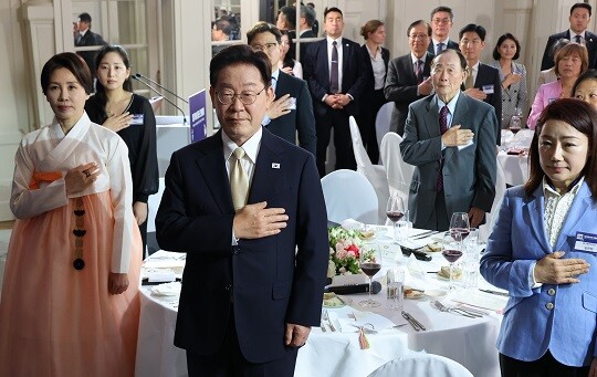 이재명 대통령과 김혜경 여사가 10월 9일(현지시각) 벨기에 브뤼셀 한 호텔에서 열린 동포 만찬간담회에서 국기에 경례하고 있다. 사진=연합뉴스