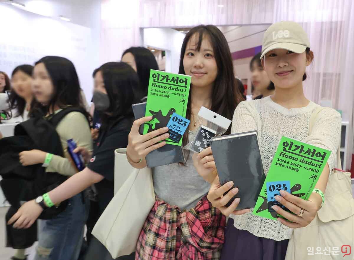 도서전 관람객이 구입한 책과 안내책자를 보이고 있다. 사진=임준선 기자
