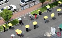 노란 우산 쓰고 코로나19 검사 기다리는 시민들