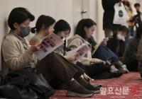 바닥에 앉아서 입시 설명회 듣는 학부모들